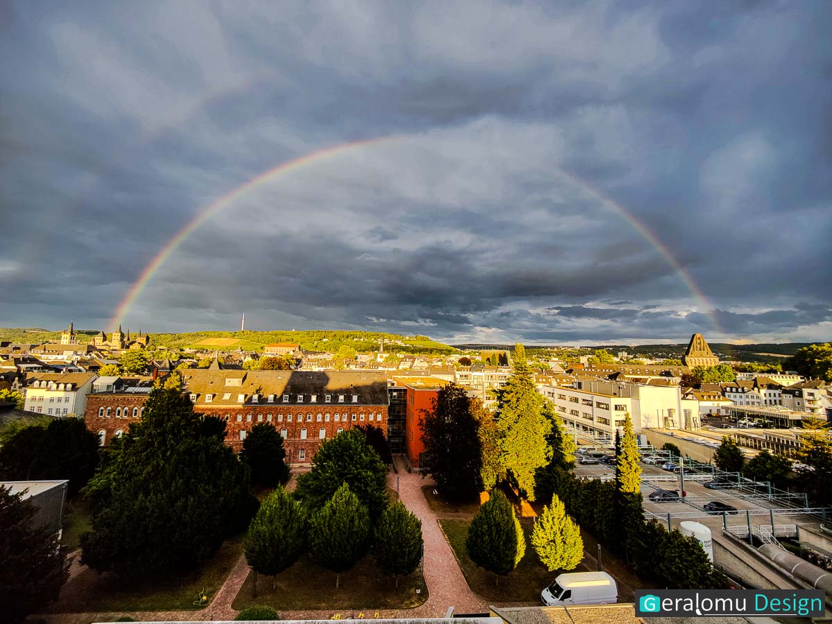 Dieses Foto aus der Landschaftsfotografie zeigt einen doppelten Regenbogen, der sich vom Trierer Dom bis zum Hochbunker über Trier spannt.