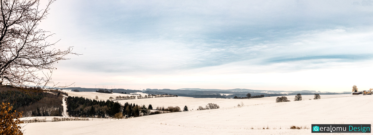 Dieses Landschaftsfoto zeigt die Panoramaaufnahme einer Winterlandschaft bei dem Ort Ellwerath im Eifelkreis Bitburg-Prüm.